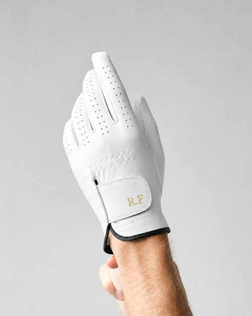 The Monogram Glove worn on a raised left hand, initials R.F on the strap.