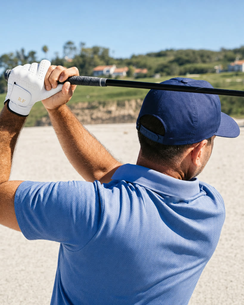 A golfer at the top of his swing in the Monogram Glove, initials R.F on the strap.